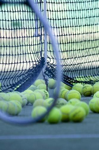 Yellow Tennis Balls and Racquet by the Net Sports and Recreation Journal